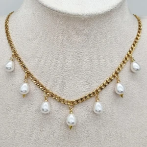 Guldhalsband med pärlhängen - Snyggt halsband i guldton med kedja och sju droppformade vita pärlor som hänger längs hela halsbandet. Perfekt för dig som vill ha en trendig accessoar med lite extra bling. 