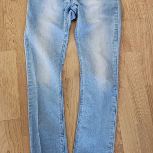 Ljusblå skinny jeans i storlek 38 - Snygga ljusblå skinny jeans i storlek 38 med klassisk femficksdesign. Jeansen har en tight passform och är tillverkade i mjukt denimtyg som ger en skön känsla. Perfekta för dig som gillar en stilren och enkel look.