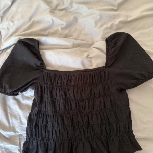 Svart smockad blus med puffärm - Supersöt svart topp med puffiga korta ärmar 