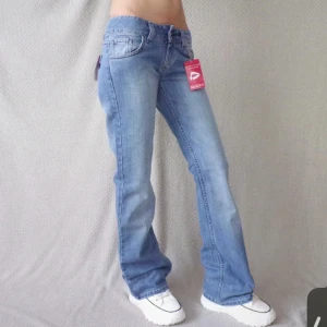 Lågmidjade jeans  - Jag säljer dambyxor Dallas Jeans – nya modell 476 färg 2BL Storlek på etiketten B 27 (69 cm) L 34 (86 cm) Mått i centimeter mätt platt i midjan 34 cm, totallängd 104 cm, längd från grenen 86 cm, benvidd nedtill 23 cm. Materialsammansättning 100% bomul. Jag fick hem dom idag och tog av lappen som dom är ej använda! 