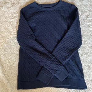 Mörkblå kabelstickad tröja  - Mörkblå kabelstickad tröja från Basic You, Ullared, i ekologisk bomull. Klassisk rund halsringning och långa ärmar💗