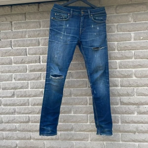 Blåa slim jeans Tiger of Sweden - Snygga blå jeans från Tiger of Sweden med slitna detaljer och hål på knäna. Modellen är slim fit med klassiska fem fickor. De är storlek 29:32 ungefär och passar allt i mellan 175-185. Inga deffekter. Nytt pris är 1600kr❌mitt pris är 399kr✅tveka inte skriv bara om det e nåt ni undrar