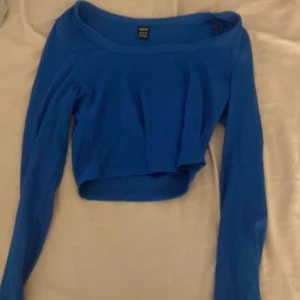 Blå croppad långärmad topp Shein - Snygg blå croppad topp från Shein med lång ärm och rundad halsringning. Ribbad struktur i tyget ger en cool känsla och toppen sitter tajt mot kroppen. Perfekt att styla med höga jeans eller kjol för en trendig look.