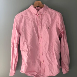 Rosa skjorta  Polo Ralph Lauren - Snygg rosa skjorta från Polo Ralph Lauren  Perfekt för dig som gillar stilrena och färgglada plagg. Skicket är 8/10 lite skrynklig men det går att stryka , fråga på om ni har frågor
