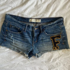 Lågmidjade Abercrombie&Fitch jeansshorts  - Supersnygga lågmidjade jeans shorts från Abercrombie & Fitch med ett F framtill och fickor baktill🫶🏼 Storlek W28! Säljer endast eftersom de är för stora😔 midjemått- 42cm