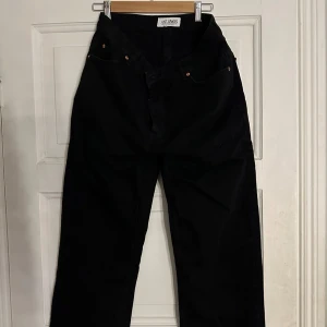 Svarta wide jeans från Just Junkies - Säljer ett par svarta jeans från Just Junkies med bred passform och klassisk femficksdesign. Jeansen har hög midja och raka, vida ben för en avslappnad och trendig look. Perfekta för dig som gillar streetstyle och vill ha en cool siluett.