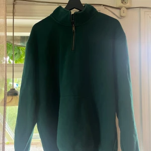 Carharrtt WIP quarter zip - Mörkgrön hoodie från Carhartt i storlek XL med quarter zip. Originalpris ca 1000kr. Gott skick.