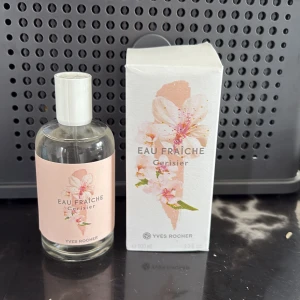 Eau Fraîche Cerisier parfym Yves Rocher - Fräsch parfym från Yves Rocher, Eau Fraîche Cerisier, med en söt och blommig doft av körsbärsblom. Flaskan är genomskinlig med vit kork och ljusrosa etikett med blomsterdesign. Kommer i matchande kartong med samma fina blommotiv. 100 ml.