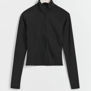 Svart tränings tröja - Svart, figurnära träningströja med hel dragkedja framtill, knappt använd! Jätteskönt material, perfekt till promenader, när du går ut och springer, idrotten eller hemma! ( soft touch) 