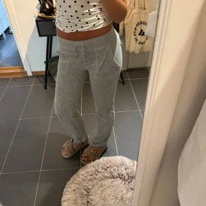 Juicy couture byxor - Små fläckar vid nedre delen av benen‼️Kan skicka fler bilder om intresset finns:) Grå mjukisbyxor med dragsko i midjan och fickor både fram och bak. Byxorna har en rak passform och är tillverkade i mjukt bomullsmaterial, perfekta för chill dagar. Snygg och enkel stil som funkar till allt.