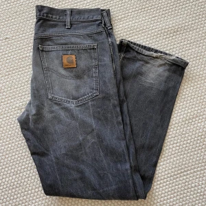 Svarta baggy / wideleg / raka jeans från Carhartt - Svarta Carhartt-jeans. Mått rakt över upptill: 46 cm. Innerbenlängd: 85 cm. Snygga att bära baggy och dra åt med skärp. 