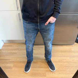 Jack & Jones Jeans - Sjukt snygga blåa Jack & Jones Comfort/Mike jeans i fint skick (Hål i högra fickan, se bild 3) därav priset. Storlek: W31/L32. Mått - Midja: 41cm Benlängd: 103cm. Hör av dig vid funderingar!🤩
