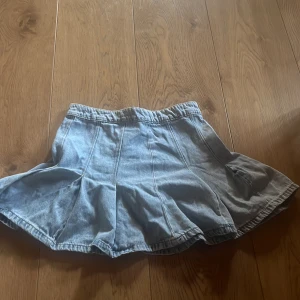 Ljusblå jeanskjol  - Supersöt ljusblå jeanskjol  med utsvängd form och markerade sömmar. Kjolen har dragkedja bak och är perfekt för dig som gillar en chill och trendig stil. Passar till sneakers eller boots för en cool look.