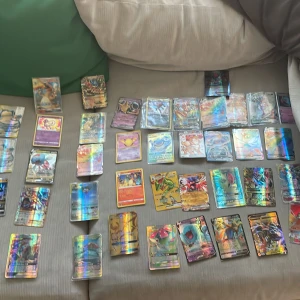 Pokémon TCG: Holo & GX/Vmax Kortsamling - En färgstark samling Pokémon-kort med många holografiska, GX och Vmax-kort! Perfekt för dig som älskar Pokémon och vill boosta din samling med coola och sällsynta kort som Charizard GX, Mew, Lucario och fler favoriter. Samlingen passar både samlare och spelare som vill sticka ut.