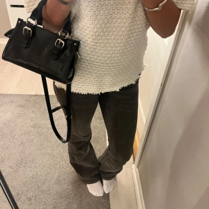 Bootcut jeans i mörkgrå denim - Säljer ett par snygga bootcut jeans i mörkgrå tvättad denim. Modellen har klassisk femficksdesign, låg midja och raka ben med lätt utsvängning.