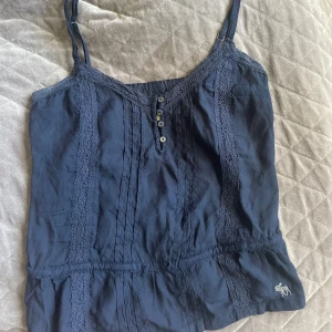 Marinblått linne - Supersöt mörkblå linnetopp från Abercrombie & Fitch. I strl xs med passar även s. Är knappt använd och axelbanden går att justera.