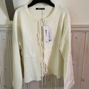 Vit kofta med snörning från Gina Tricot - Supersnygg vit kofta från Gina Tricot med snörning framtill som ger en cool touch. Mjuk och skön kvalitet. Aldrig använd och pris sitter kvar.