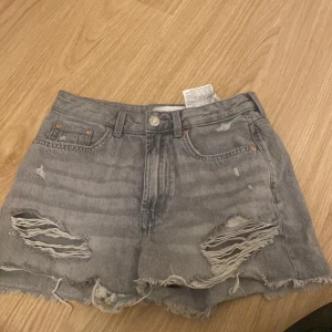 Grå jeansshorts Stradivarius vintage - Snygga grå jeansshorts från någon butik i Spanien 🇪🇸.Perfekt för dig som gillar en edgy och avslappnad stil.