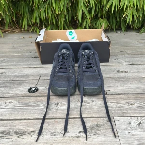 Nike Air Force 1 Low ’07 Cordura Dark Obsidian - Nike Air Force 1 sneakers i mörkblå färg med Cordura-material för extra slitstyrka. Skorna har snörning, rund tå och platt sula. Swoosh-logga på sidan och AIR-detalj på sulan. Skorna är knappt använda och är äkthetsverifierade av sneak.se. Skorna kostar ungefär 2000-2500kr helt nya.