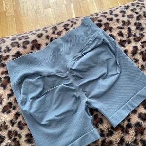 Grå högmidjade träningstights-shorts - Snygga gråa shorts med hög midja och ribbad linning. De är tillverkade i mjukt och stretchigt syntetmaterial som sitter skönt mot kroppen. Modellen är tight och följsam. Identiska med Impact från DFYNE. 