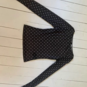 Svart mesh topp med vita prickar - Säljer en svart mesh topp från Hm med vita prickar. Toppen är långärmad och har en tight passform med transparent material. 
