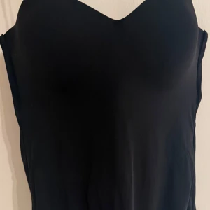 Svart body - Snygg svart body med hjärtformad urringning. Enkel och stilren design som passar perfekt till höga jeans eller kjol. 