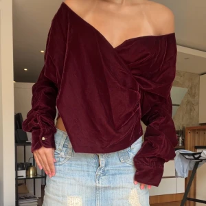 Vinröd omlottblus i sammet Lauren Ralph Lauren - Supersnygg vinröd omlottblus från Lauren Ralph Lauren i mjuk sammeti storlek xs. Den går att ha offshoulder men även som en vanlig blus med v ringning. Den är helt ny och aldrig använd, köpt för 2500kr