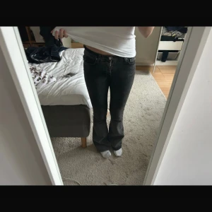Svarta bootcut jeans med låg midja - Säljer ett par svarta jeans med snygg bootcut och låg midja. Jeansen har klassisk femficksdesign och är tillverkade i ett mjukt jeansmaterial som sitter skönt. Från Gina Tricot