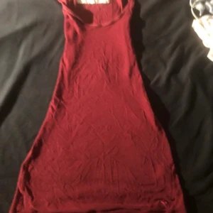 Vinröd Linne Abercrombie & Fitch Kommer med prislapp - Säljer en vinröd Linne från Abercrombie & Fitch. Klänningen är ärmlös med rund hals och har en slim passform. Materialet är mjukt och ribbat, vilket ger en skön känsla och snygg siluett. Perfekt för dig som gillar enkel och stilren design.