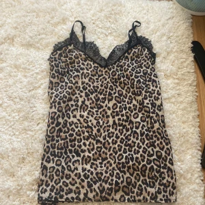 Spets linne leopard - Säljer ett spets linne i leopard, aldrig använt själv men är köpt på Plick så vet inte hur använt det är. Men inga synliga tecken på användning💞