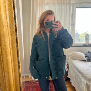Grön quiltad jacka - Säljer en mörkgrön quiltad jacka med dragkedja framtill och stora fickor. Jackan har en oversized passform och långa ärmar, perfekt för sommarkvällar och vår. Snygg och trendig modell som passar till många olika stilar.