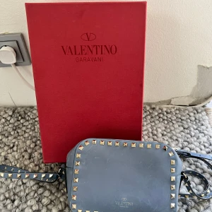 Valentino garavani camera bag - Säljer denna så underbara valentino garavani väskan! Köpt på vestaire collective där den genomgått en ”äkthetskoll” av experter som kollat att den är äkta! Har dock inget kvitto men kan garantera med box, dustbag och stämplar på väskan att den är 100% äkta! Några scratches/repor hit och dit på framsidan, men det är inget som syns lite längre ifrån om man inte undersöker den noggrant! Kontakta för frågor och fler bilder! Köptes för 8000 (nypris 12,000) 💙 så snygg blå färg och fin till vår/sommar