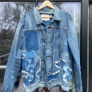 Unik jeansjacka från Levi's - Unik jeansjacka från Levi's med flera patchade detaljer i olika blå nyanser och slitningar. Perfekt skick och Japan made! Skicka pm för fler frågor.