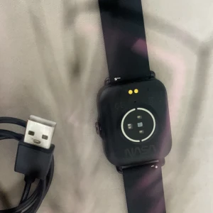 Svart smartklocka från NASA - Säljer en svart smartklocka från NASA med tillhörande laddkabel. Klockan har en fyrkantig urtavla och silikonarmband. Perfekt för dig som gillar teknik och rymdtema!           Pris kan diskuteras!!        köpte den för 1200 
