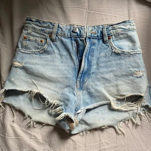 Ljusblå jeansshorts med fransar från Zara - Fina shorts från zara som är högmidjade men dom är fina om man viker ner dom också. Knappt använda❤️