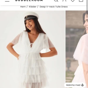 Studentklänning - Superfin vit klänning med flera lager volanger och transparenta korta ärmar. Djup v-ringning framtill och öppen rygg med knytband. Perfekt för studenten! Helt slutsåld! 