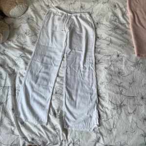 Vita linnebyxor som är lågmidjade  - Säljer ett par vita linnebyxor i storlek XS. Byxorna har rak passform, resår i midjan och är tillverkade i ett tunt och luftigt linnematerial. Perfekta för varma dagar och enkel att matcha med olika toppar.