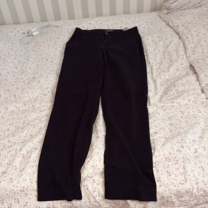 Svarta kostymbyxor med raka ben - Säljer ett par svarta kostymbyxor med raka ben och klassisk passform. Byxorna har hällor för bälte och två fickor bak. Perfekta till en stilren look.