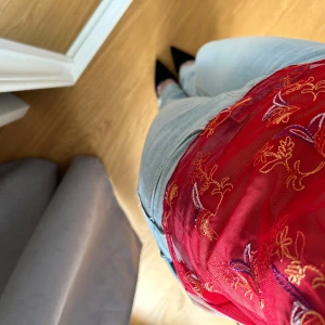 Röd broderad mesh-linnetopp - Säljer en röd mesh-linnetopp med tunna axelband och v-ringning. 