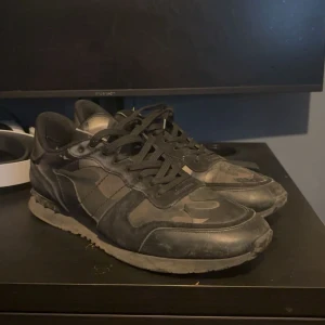 Valentino Rockrunner sneakers i svart camo - Säljer ett par svarta Valentino Rockrunner sneakers med kamouflagemönster. Storlek 45 jag skulle säga att det är rätt små i storlek så det passar 44, man får med en sko påse, snörren, kort. Kan skicka fler bilder på de med