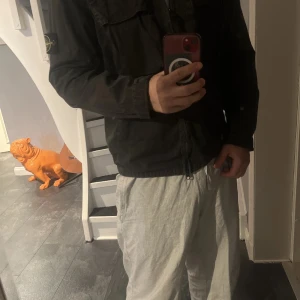 Svart overshirt från Stone Island - Säljer en svart overshirt från Stone Island med klassisk logotyp-patch på ärmen. Jackan har två bröstfickor med lock och knappar samt dragkedja framtill. Säker byten mot skor helst, eller Ralph lauren skjorta.