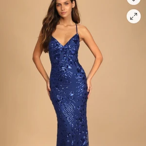 Blå paljettklänning med snörning i ryggen - Helt ny balklänning från Lulus. Säljer den pga att den är för stor (kolla sista bilden), plus att det var krångligt med returen. På hemsidan kostar den 1300kr men säljer den för 1000kr, men pris kan diskuteras privat.