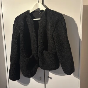 Svart teddyjacka - Mysig svart teddyjacka med knappar framtill, den har även två fickor fram som stängs med knappar, storlek xxs men skulle säga att den är som en xs/s. Den är lite hårig då det finns hund i hemmet. 