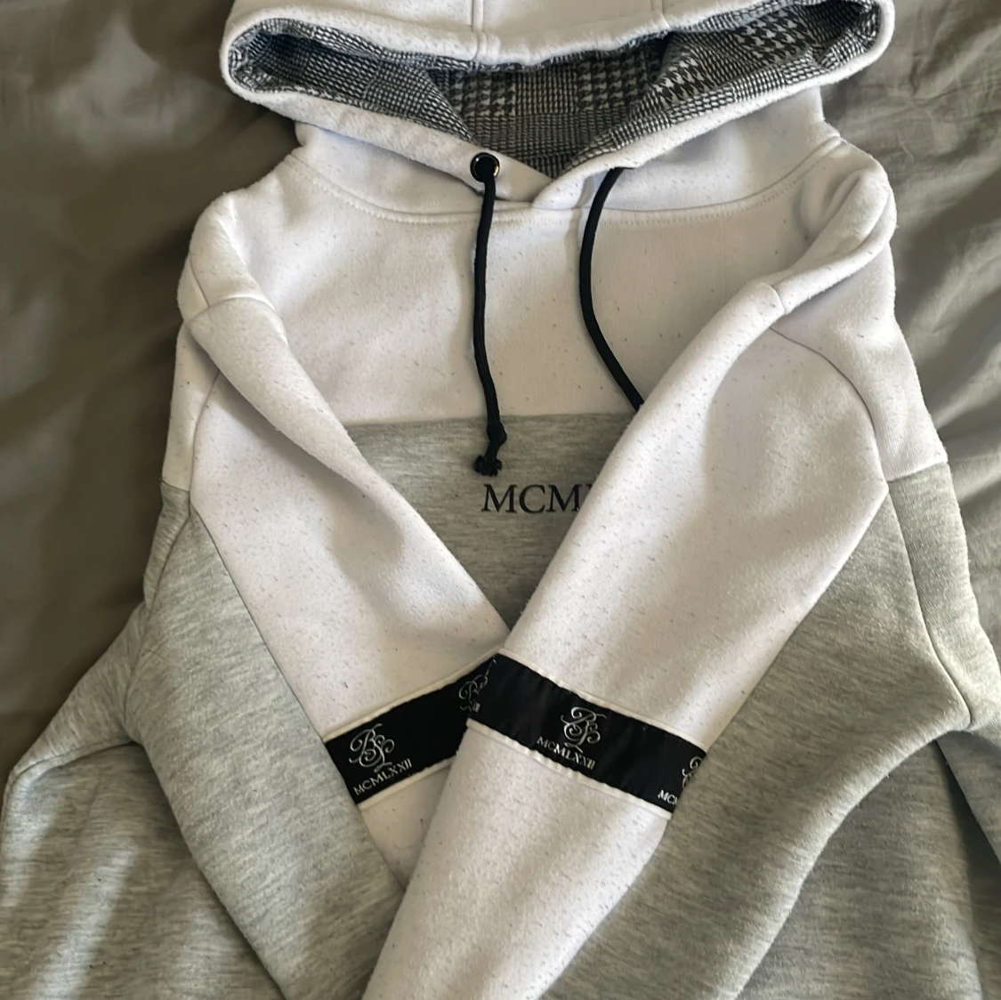 Grå och vit hoodie.