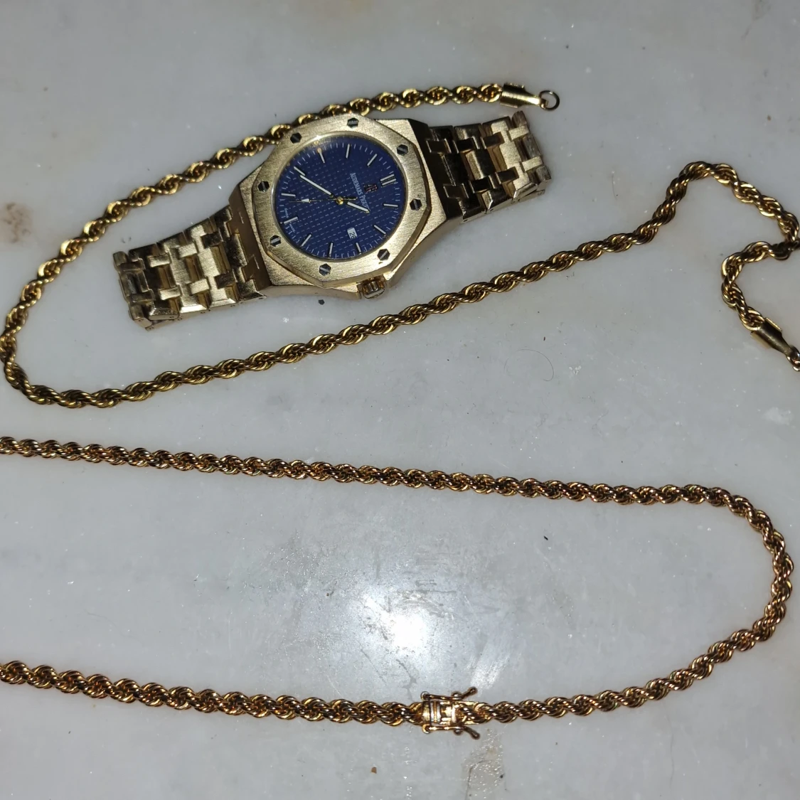 Guldfärgad klocka med blå urtavla och cordell