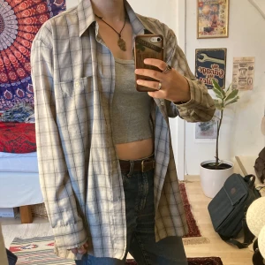 Rutig skjorta från Club Euro, L - Snygg rutig skjorta från Club Euro i storlek L. Skjortan är i ljusa toner av grått och beige, har klassisk krage, knäppning framtill och långa ärmar. Tycker mycket om den, men använder tyvärr för sällan!