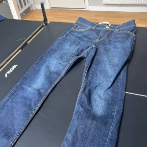 Levi's 512 Slim Taper jeans blå - Säljer ett par Levi's 512 Slim Taper jeans i mörkblå denim. Klassisk femficksmodell med snygga kontrastsömmar och läderpatch bak. Jeansen har smal passform med avsmalnande ben och är tillverkade i slitstarkt bomullsmaterial.