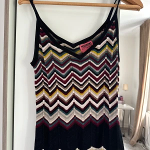 Missoni mönstrad linnetopp  - Säljer en ikonisk linnetopp från Missoni med färgglatt zigzag-mönster i vinrött, blått, svart, gult och beige. Tunt stickat material med smala axelband och v-ringad hals. Perfekt för dig som gillar statement-plagg och coola retrovibbar.