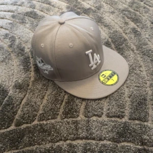 New era keps LA grå - Säljer en helt ny New era keps LA som är grå. Den är aldrig använd och säljer den eftersom den är liten för mig och orkade inte skicka tillbaka den. Jag kan mötas upp i Skövde annars frakt. Strlk 55.8CM
