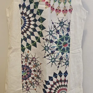 Vit kortklänning med färgglatt mönster - Snygg vit kortklänning från Desigual med ärmlös design och färgglada geometriska mönster framtill. Klänningen har dragkedja i sidan och är tillverkad i ett mjukt bomullstyg. Perfekt för dig som gillar unika och färgstarka plagg.